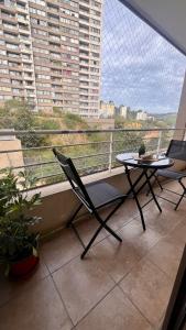 a balcony with two chairs and a laptop on a table at Apartment with parking in Valparaíso