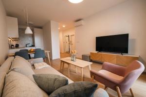 un salon avec un canapé et une télévision à écran plat dans l'établissement Nest 5B, à Bratislava