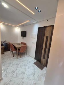 アル・ホセイマにあるAppartement rif roayalのテーブルと椅子とテレビのある部屋