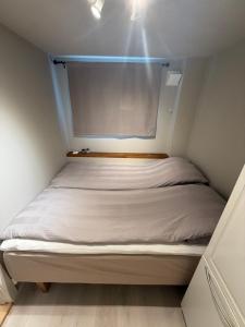 a small bedroom with a bed in a small room at Sentral og koselig leilighet in Tromsø