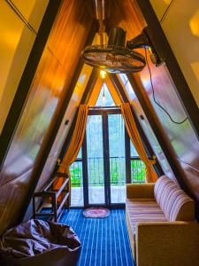 salon z kanapą i dużym oknem w obiekcie White Moon Cabin & Cottage w mieście Ella