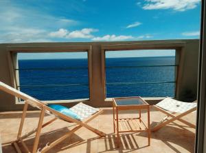 two chairs and a table on a balcony overlooking the ocean at Ático encima del mar in Santa Cruz de la Palma