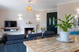 a living room with a couch and a table with a plant at Villa Leveque - Kassiopi Sea View - 3 bedrooms in Kassiopi