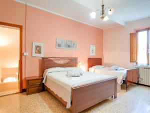 Dos camas en un dormitorio con paredes rosas. en Tuscany Family Country Home, en Chianni