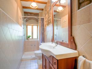 Un baño con lavabo, inodoro y espejo. en Tuscany Family Country Home, en Chianni