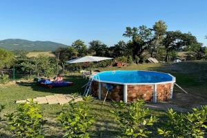 una mujer tendida en el césped junto a una piscina en Tuscany Family Country Home, en Chianni 32 fotos más
