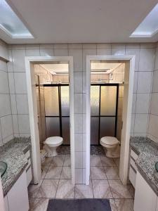 a bathroom with two toilets and two sinks at Apê Brisa do Mar in Pontal do Paraná +18 photos