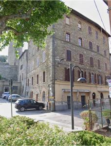 a large brick building with a car parked in front of it at Trasimeno Vacanze in Passignano sul Trasimeno