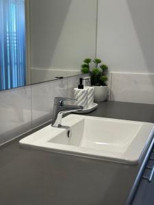 a white sink in a bathroom with a mirror at Ocean View Beach House !! in Mandurah +11 photos