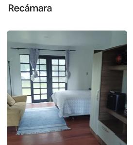 a bedroom with a bed and a couch and a television at Cabaña Bosque cerca playas in Valdivia