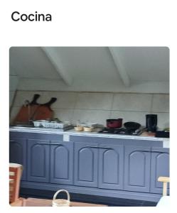 a blue kitchen counter top with pots and pans at Cabaña Bosque cerca playas in Valdivia