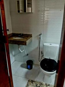 a small bathroom with a toilet and a sink at Apartamento na praia 2 qt com quintal e churrasqueira in Itanhaém