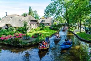 a group of people riding in gondolas down a river at De Zaandbarg in Nijeveen