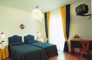 ein Schlafzimmer mit einem blauen Bett und einem TV in der Unterkunft Bike-Hotel Abete in San Giovanni Rotondo