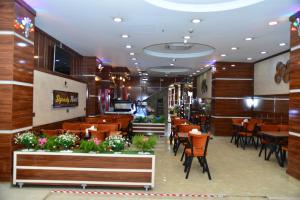 ein Speisesaal mit Tischen und Stühlen und ein Restaurant in der Unterkunft Dynasty Hotel in Erbil