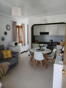 a kitchen and living room with a table and a couch at Apartament La Mata -Maya Bungalow in Torrevieja
