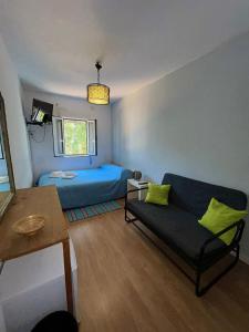 a living room with a blue bed and a couch at Casa do Ruben Lisboa in Lisbon