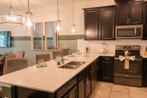 a kitchen with a sink and a counter top at Disney Magic ChampionsGate Resort House 15 min from Disney World, with Club House, 7 Pools and Water Park in Kissimmee