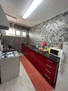 a kitchen with red cabinets and a white refrigerator at Casa do Ruben Lisboa in Lisbon +11 photos