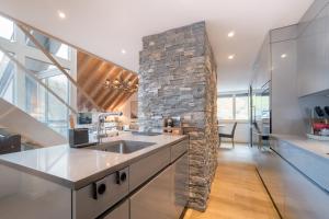 a kitchen with a stone wall and a sink at Swiss Family Chalet in Andermatt