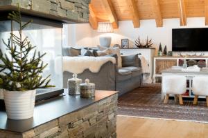 a living room with a couch and a christmas tree at Swiss Family Chalet in Andermatt