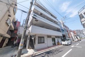 a building on the corner of a city street at Breeze Stay Shiohama in Tokyo