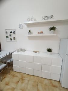 a kitchen with white cabinets and a dining table at A casa di Irene in Le Marmore