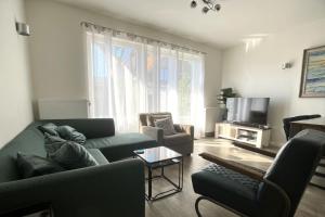 a living room with a couch and a tv at Sleedoornstraat 3 in Cadzand