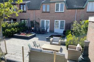 a patio in front of a house with chairs and tables at Sleedoornstraat 3 in Cadzand