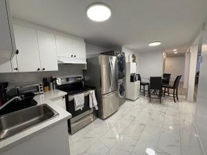 a kitchen with stainless steel appliances and a table at Private Basement Suite in Laval in Laval