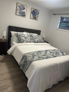 - une chambre avec un grand lit et une couette blanche dans l'établissement Private Basement Suite in Laval, à Laval