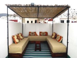 a pergola on top of a balcony with couches at Riad la madriguera de Tetuan in Tétouan