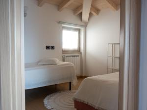 a bedroom with two beds and a window at Casa Raki in Parzanica +35 photos