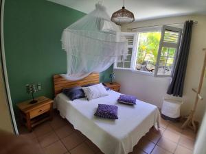 a bedroom with a bed with two pillows on it at Belle Villa 3 chambres piscine Rivière Salée in Rivière-Salée