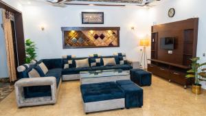 a living room with a couch and a tv at Cozy 2-Bed Lower Portion with Kitchen & Parking in Lahore