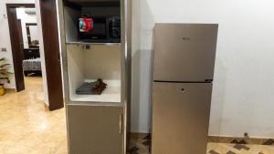 a refrigerator in the corner of a room at Cozy 2-Bed Lower Portion with Kitchen & Parking in Lahore +15 photos