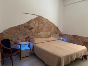 een slaapkamer met een bed en een stenen muur bij Terrace Garden Apartment in Acitrezza