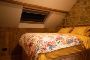 a bedroom with a bed with a floral blanket on it at Abri du fûret in Lustin
