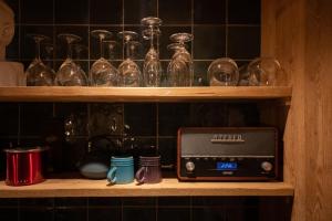 a shelf with a radio and glasses on it at Abri du fûret in Lustin