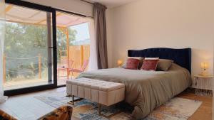 a bedroom with a bed and a large window at Terras do Salvado Agroturismo in Fundão