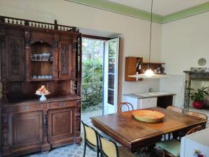 a kitchen with a table and a large wooden cabinet at Magnifica villa di fine '800 in Blevio