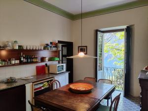 a kitchen with a table and a dining room at Magnifica villa di fine '800 in Blevio