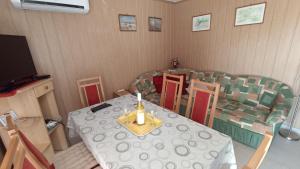 a dining room with a table and chairs with a candle on it at Ottó Nyaraló in Révfülöp