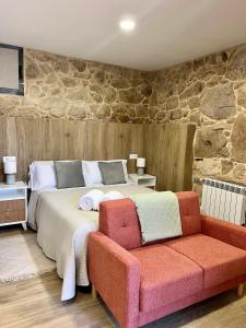 Un dormitorio con una cama grande y un sofá. en Casa rural Reibón, en Moaña