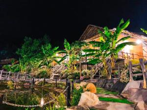 a house at night with a bunch of trees at HomeStay Thiên Phúc in Ấp Ðinh An (1)