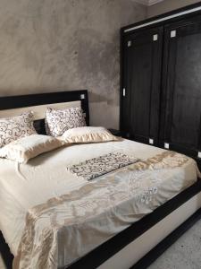 a large bed with a black headboard and pillows at Tiba soliman plage in Nabeul +108 photos