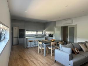 a kitchen and living room with a couch and a table at MiraReal Guest House in Macieira da Lixa