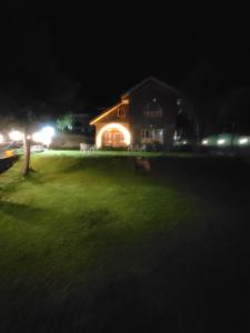 a house lit up at night with a green yard at Winterfell the Stay Cottage Pahalgam in Pahalgām