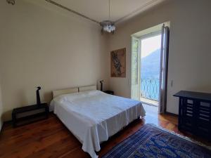 a bedroom with a bed and a large window at Magnifica villa di fine '800 in Blevio