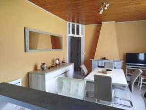 a living room with a table and chairs and a television at Maison de vacances à Lesperon in Lesperon